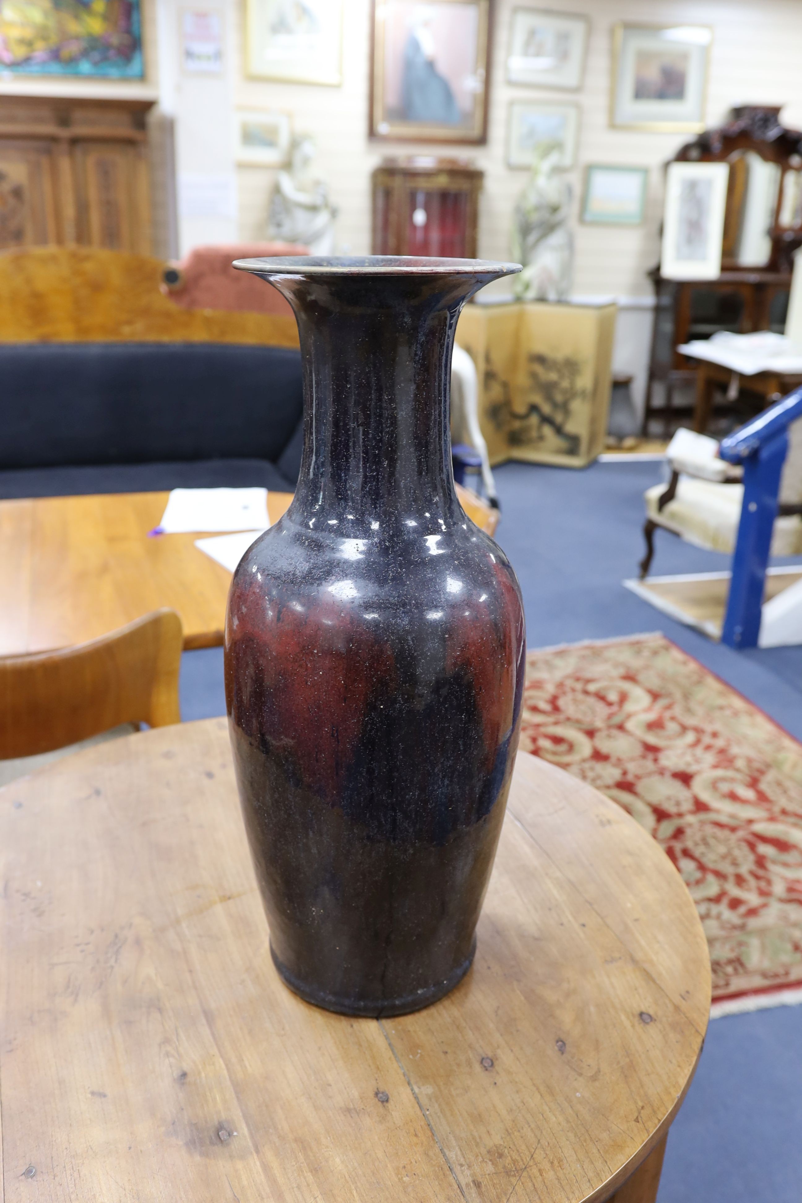 A large Chinese sang de boeuf glazed vase on carved wooden stand., Vase 61 cms high not including stand.